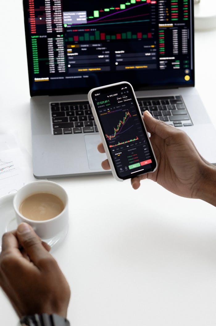 services-01 Person analyzing stock market trends on smartphone with laptop background